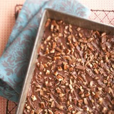 a pan filled with chocolate and nuts on top of a table