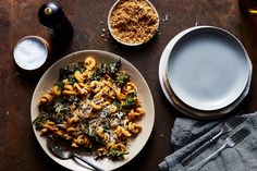 a plate of pasta with spinach and parmesan cheese next to a bowl of soup