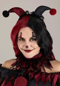 a woman dressed as a clown with red hair and black makeup is smiling at the camera