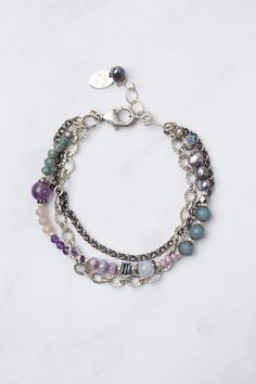 Experience the beauty and versatility of the Reflections Collection. Each piece is thoughtfully handcrafted using carefully chosen materials. This multistrand bracelet measures 7.5-8.5" and is completed an antique silver plated brass extender chain and lobster claw clasp. Elevate your style with Reflections. Antique Silver Plated Brass (lead and nickel free) Amethyst, Blue Lace Agate, Pearl 7.5-8.5", adjustable with antique silver plated brass lobster claw clasp We hand select our natural materi Adjustable Silver Beaded Fusion Bracelet, Adjustable Bohemian Sterling Silver Chain Bracelet, Silver Double Strand Bohemian Jewelry, Bohemian Silver Double Strand Jewelry, Bohemian Double Strand Silver Jewelry, Adjustable Sterling Silver Beaded Fusion Bracelets, Nickel-free Adjustable Multi-strand Bracelets, Bohemian Silver Bracelets With Adjustable Chain, Spiritual Multi-strand Czech Glass Jewelry