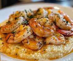 a white plate topped with shrimp and grits