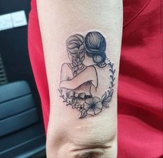 a woman's arm with a tattoo on it that has two women hugging each other