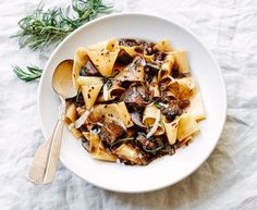 a white bowl filled with pasta and mushrooms