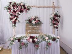 an arrangement of flowers and greenery decorates the head table at a wedding reception