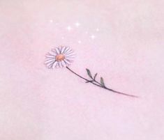 a single flower tattoo on the back of a woman's shoulder