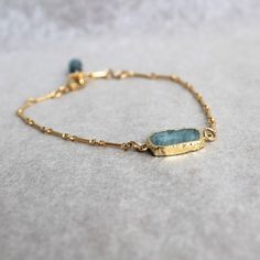 "Subtle shades of tropical waters in pale blue and bright gold,  These rough slices of aquamarine are dipped in gold plate.  Bracelet chain and  clasp are all gold filled.  A delicate gold-filled wrapped aquamarine stone finishes the bracelet.  Adjustable size 7\"-8\" The earrings can be purchase separately at https://www.etsy.com/listing/1163103992/rough-cut-aquamarine-with-gold-dangles?click_key=a8a3c24b59a65ea05319c8bce692c0718c5b2a90%3A1163103992&click_sum=b772d68a&ref=shop_home_active_5&frs Dainty Aquamarine Gold Jewelry, Elegant Gold Aquamarine Bracelet, Minimalist Gold Aquamarine Jewelry, Gold Amazonite Bracelet Jewelry, Gold Amazonite Bracelet, Amazonite Bracelet Jewelry In Gold, Gold Aquamarine Jewelry With Natural Stones, Gold Aquamarine Bracelet Gift, Moss Aquamarine