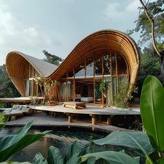 a bamboo house with an outdoor patio and seating area next to the water, surrounded by greenery