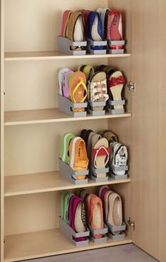 several pairs of shoes are on shelves in a closet