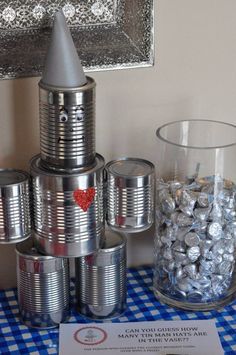 several tin cans are stacked on top of each other with candy in front of them