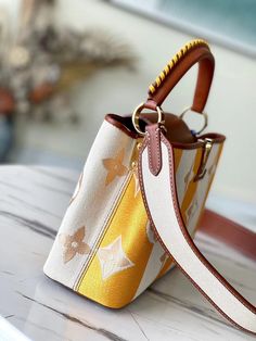 Made from colorful striped canvas with natural leather trim, this adorable Capucines BB handbag has a two-color braided leather top handle as well as a wide removable strap. The embroidered Monogram flowers motif on the edges of the summery stripes adds the final touch of Louis Vuitton style. Detailed Features 27 x 18 x 9 cm (Length x height x width ) Yellow Smooth calfskin and embroidered canvas Smooth-calfskin and embroidered-canvas trim Cowhide lining Gold-color hardware Double carry style: f Capucines Louis Vuitton, Louis Vuitton Capucine, Louis Vuitton Capucines, Lady Bags, Embroidered Canvas, Embroidered Monogram, Coach Bag, Braided Leather, Natural Leather