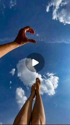 two people reaching up into the sky with their hands on each other's legs