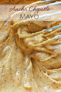 a bowl filled with yellow sauce and two white whisks in the batter for making ancho chipotle mayo