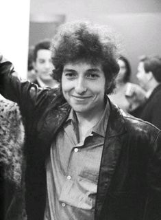 a black and white photo of a young man in a leather jacket smiling at the camera