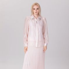 A sophisticated piece featuring a classic line cut in slightly transparent organza. Decorated with pearls on the edges of the collar and on the top of the placket. Wear with tapered pants or a high skirt, for elegant and semi-formal occasions. Main material: 100% Polyester. Lining: 100% Polyester. Washing temperature 30° maximum in delicate cycle. Low ironing temperature / bleaching prohibited. Do not tumble dry. Elegant Sheer Blouse For Spring, Classic Sheer Evening Blouse, Spring Formal Blouse With Embellished Collar, Elegant Pearl-embellished Blouse For Wedding, Elegant Blouse With Embellished Collar For Work, Spring Formal Embellished Blouse, Elegant Sheer Collared Blouse, Elegant Sheer Blouse For Evening, Elegant Blouse With Embellished Collar For Formal Occasions