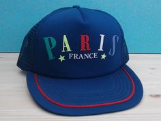 This is a very interesting Paris, France snapback. The bill is very long, pretty cool looking.  Cap is very colourful and in nice shape. Nothing bad to say about it. One size snaps all. Vintage Blue Adjustable Trucker Hat, Vintage Blue Snapback Baseball Cap, Vintage Blue Adjustable Baseball Cap, Vintage Adjustable Blue Baseball Cap, Retro Blue Trucker Hat For Streetwear, Retro Blue Cap Hat, Blue Retro Trucker Hat For Streetwear, Retro Blue 5-panel Trucker Hat, Retro Blue Cap