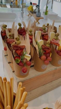 food items displayed on wooden trays with utensils in front of them, including tomatoes and olives