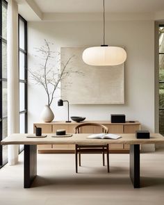 a modern dining room with an art work on the wall and table in front of it