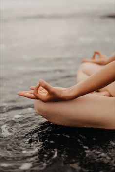 a woman sitting in the water with her hands together