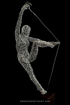 a wire sculpture of a woman with a bow and arrow in her hand, on a black background