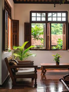 two wooden chairs sitting in front of a window