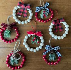 four christmas ornaments hanging from strings on a wooden floor