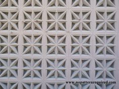 a close up view of a wall made out of white bricks with geometric designs on it