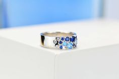 a close up of a ring with blue stones on the inside and silver in the outside