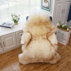 a chair that has some kind of animal fur on it's back, in front of a window