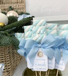 some blue and white candy sticks are in a basket with christmas decorations on the table