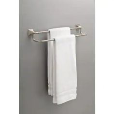 a towel rack with two white towels hanging from it's sides on a gray wall