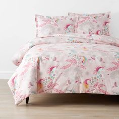 a bed with pink and blue floral comforters