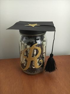 a graduation cap on top of a jar filled with money