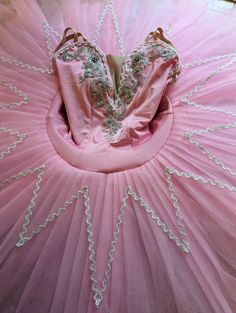 A  pink ballet tutu. This is a stretch tutu with 9 layers of stiff tulle.The bodice is a pale pink velour stretch fabric adorned with silver trim. The skirt is made from pink stiff  with a silver appliqué star. The skirt has a flexible hoop and the skirt stands straight as a pancake tutu should. Please check your measurements against the size chart or send in your measurements for custom made.  We also need your telephone number for the shipping company. All tutus are sent direct from our work s Pink Stretch Tulle Tutu Dress, Fitted Pink Balletcore Tutu Dress, Pink Fitted Balletcore Tutu Dress, Pink Ballet Tutu Dress In Tulle, Pink Ballet Tutu Dress With Tulle Skirt, Pink Fitted Ballet Tutu Dress, Pink Tulle Tutu Dress For Dance, Princess Style Fitted Tutu Dress For Dance, Pink Ballet Tutu Dress