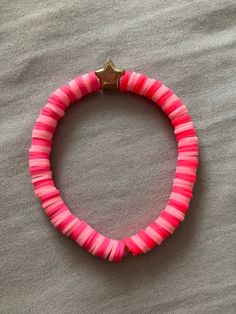 a pink bracelet with a gold star on it