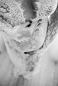 black and white photograph of a woman's stomach with her hands on her chest