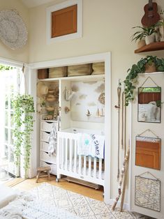 a white crib in the corner of a room with wooden shelves and potted plants