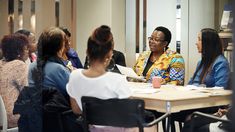 a group of women sitting around a table talking