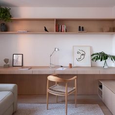 a living room with a couch, desk and shelves on the wall next to it