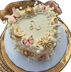 a heart shaped cake with flowers and butterflies on it's side sitting on a plate