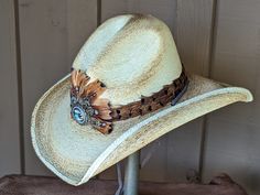 This is the perfect hat for rocking out to your favorite band, touring Nashville, or cheering on your favorite cowboy at the rodeo. Western Style Concho Hats For Country Events, Western Straw Hat For Kentucky Derby, Southwestern Fedora Straw Hat For Western-themed Events, Western Style Straw Hat For Festivals, Western Concho Hat Bands For Country Events, Adjustable Feather Hat Bands For Summer, Southwestern Straw Hat With Flat Brim For Western-themed Events, Western Style Straw Hat For Kentucky Derby, Feathered Hat Bands For Beach Events In Summer