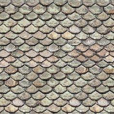 an old stone wall with many different colors and patterns on it's surface, as well as the top part of its roof