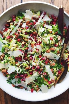 a white bowl filled with salad topped with pomegranates