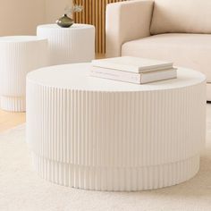 a white table sitting on top of a rug next to a couch