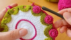 someone is crocheting a circular with pink and green yarn