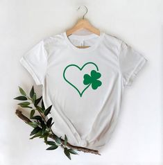 Shamrock Heart Shirt, Lucky Shirt, Saint Patricks Day Shirt, St Paddys Day Shirt, Shamrock Shirt, St Patrick's Day, Luck of the Irish Shirt*** How to Order ***Please choose your t-shirtPlease choose your t-shirt colorPlease type your design color ( Black or White)Thank you for choosing us*** Product ***4.2 oz., 100% airlume combed and ringspun cotton, 32 singlesAthletic Heather and Black Heather are 90/10 airlume combed and ringspun cotton/polyester *** Production and Shipping ***Production time White Shirt With Heart Graphic As Gift, Crew Neck Shirt With Heart Graphic For Gift, Crew Neck Shirt With Heart Graphic As Gift, Casual Heart-shaped Shirt For Gift, Theatre Shirts, Grammy Gift, Theatre Gifts, Nerd Shirts, St Paddys