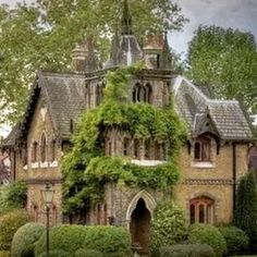 an old building with ivy growing on it's side and trees in the background