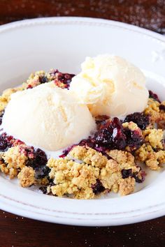 two scoops of ice cream sit on top of a crumbled oatmeal