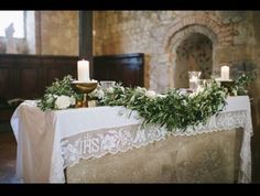 the table is decorated with greenery and candles