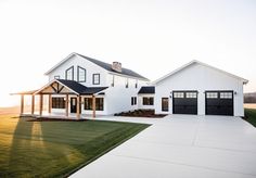 a large white house with two garages on the side