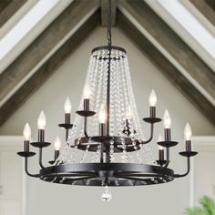 a chandelier hanging from the ceiling in a room with white walls and wooden beams